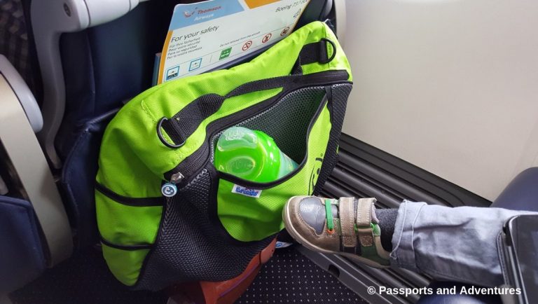 Awesome Tips For Flying With Babies and Toddlers - A Trunki insert bag on the back of an airplane seat