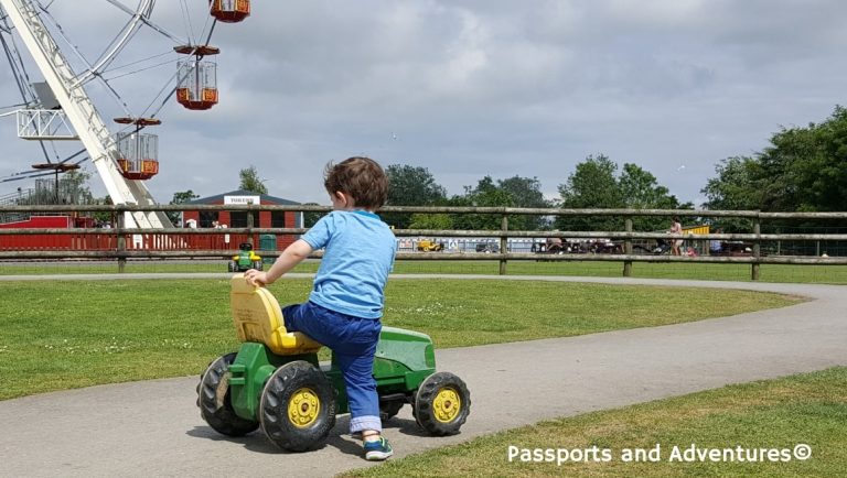 Boy getting onto a ride-on tractor at Folly Farm Adventure Park and Zoo