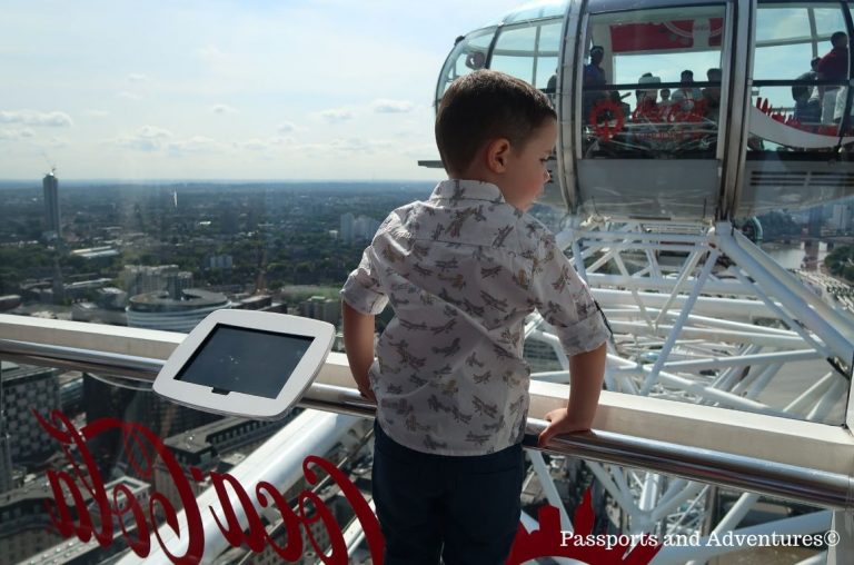 A little boy looking out of the glass windows of a capsule at the London Eye