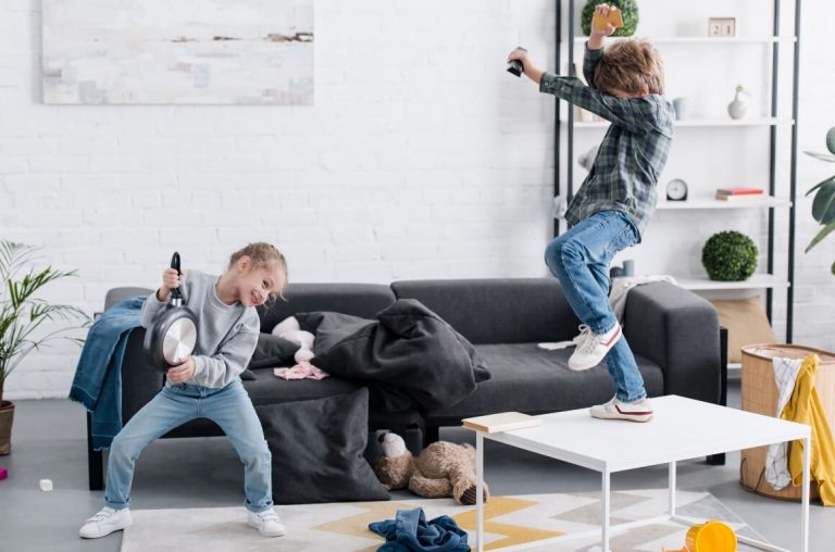 Two kids dancing and rocking in a living room