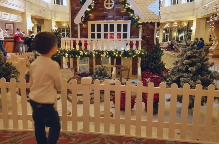 A little boy in front of the gingerbread house in the lobby of the Disneyland Paris Hotel