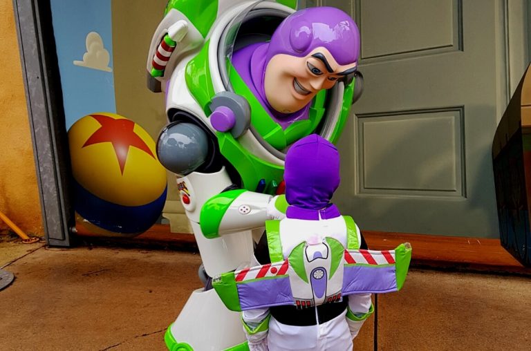 A little boy in a Buzz Lightyear costume meeting the character Buzz Lightyear in Disneyland Paris