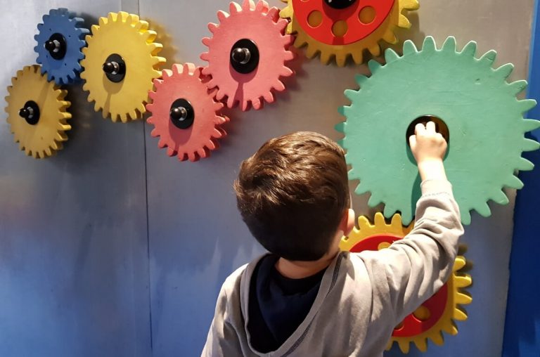 A young boy playing with cog wheels in Imaginosity, the Dublin Children's Museum