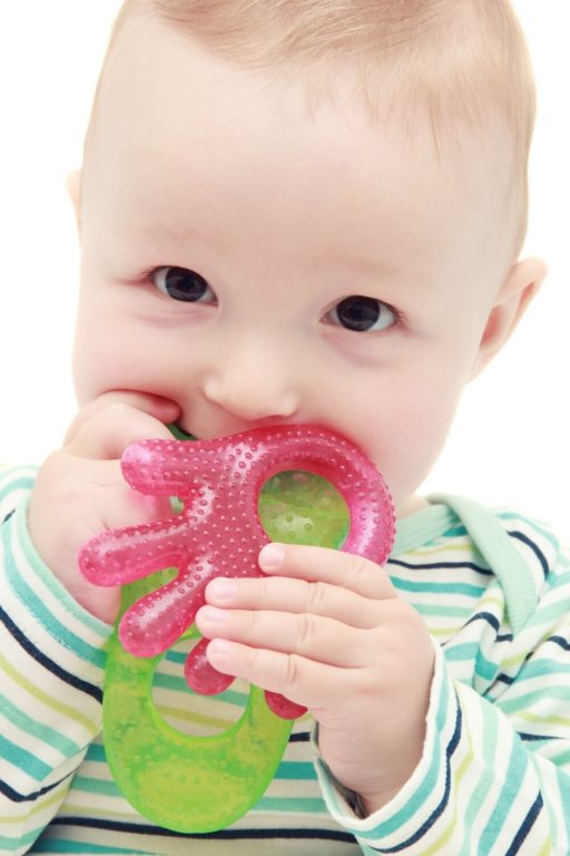 A picture of a baby with a pink and green teething toy in their mouth